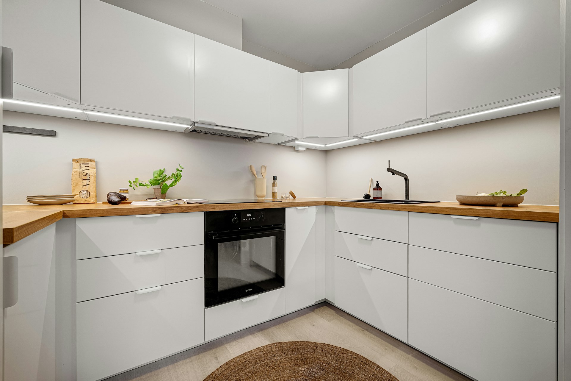 A kitchen with white cabinets and a black stove top oven